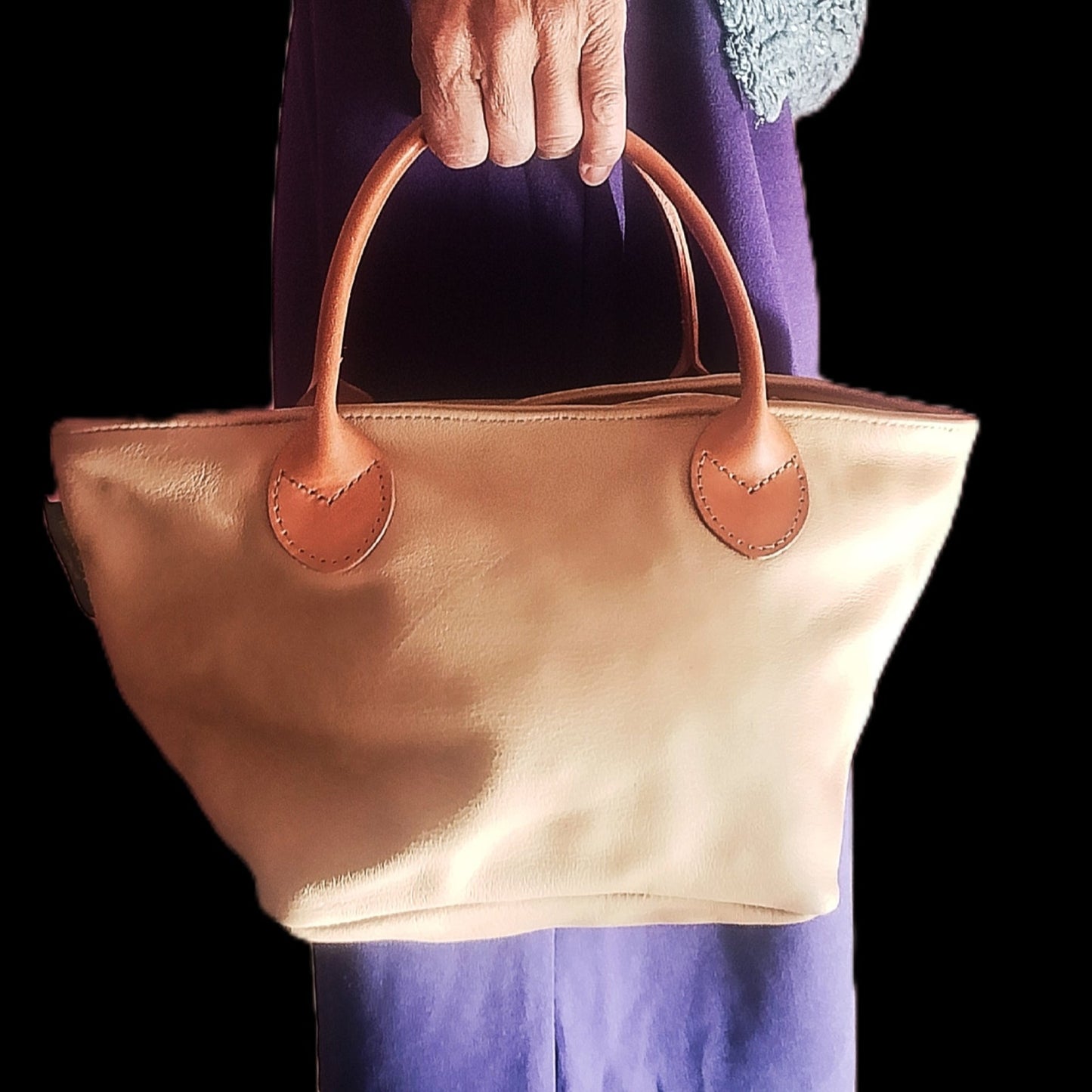 Bolso de piel beige de la mano de mujer