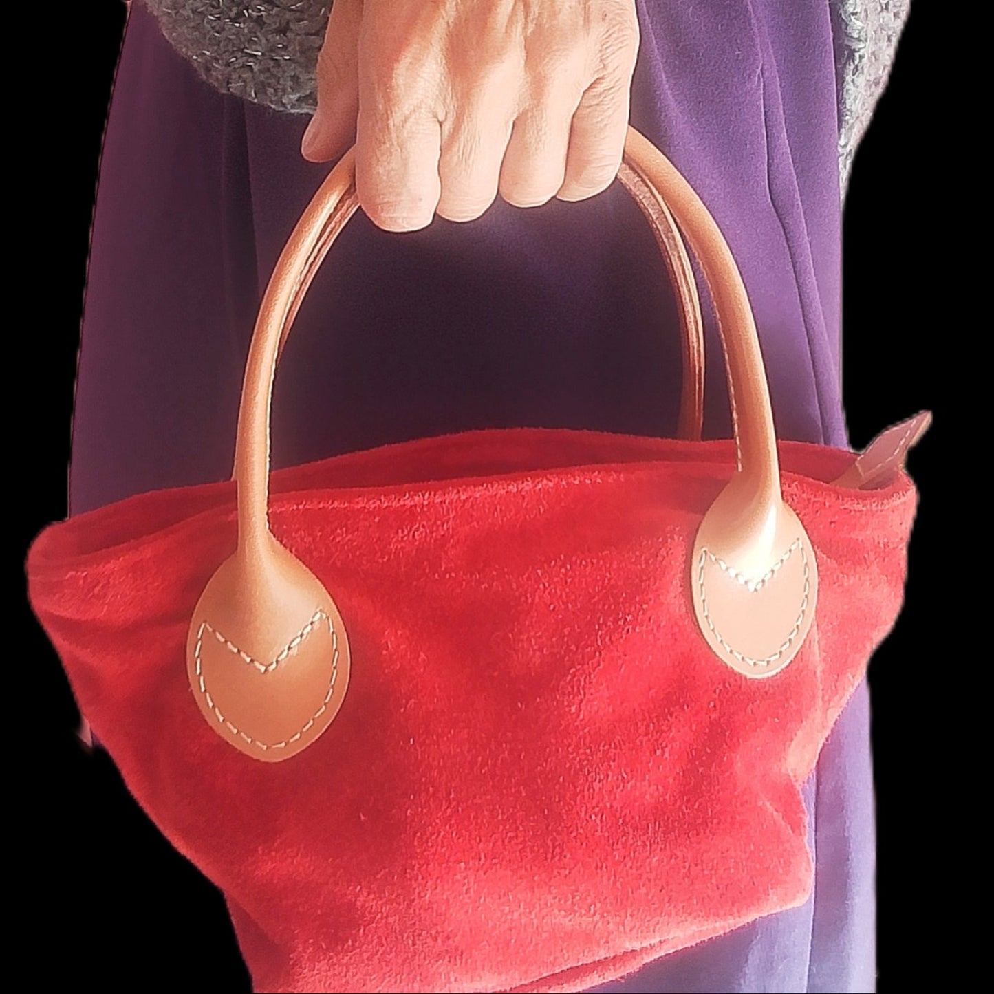 Bolso rojo de ante rojo de la mano de mujer