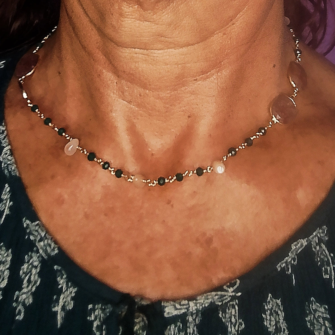 gargantilla de piedras naturales de color verde oscuro y piedras beige puesta sobre cuello de mujer