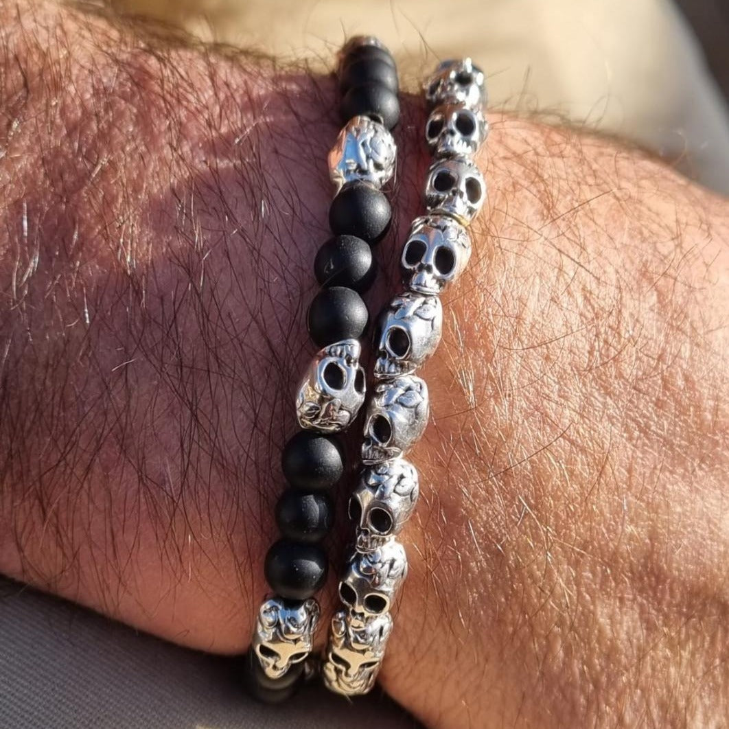 Pulsera de 3 bolas de onix alternadas con una calavera de metal y pulsera todas de calaveras