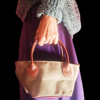 Bolso loneta verde y asas marrones de la mano de mujer