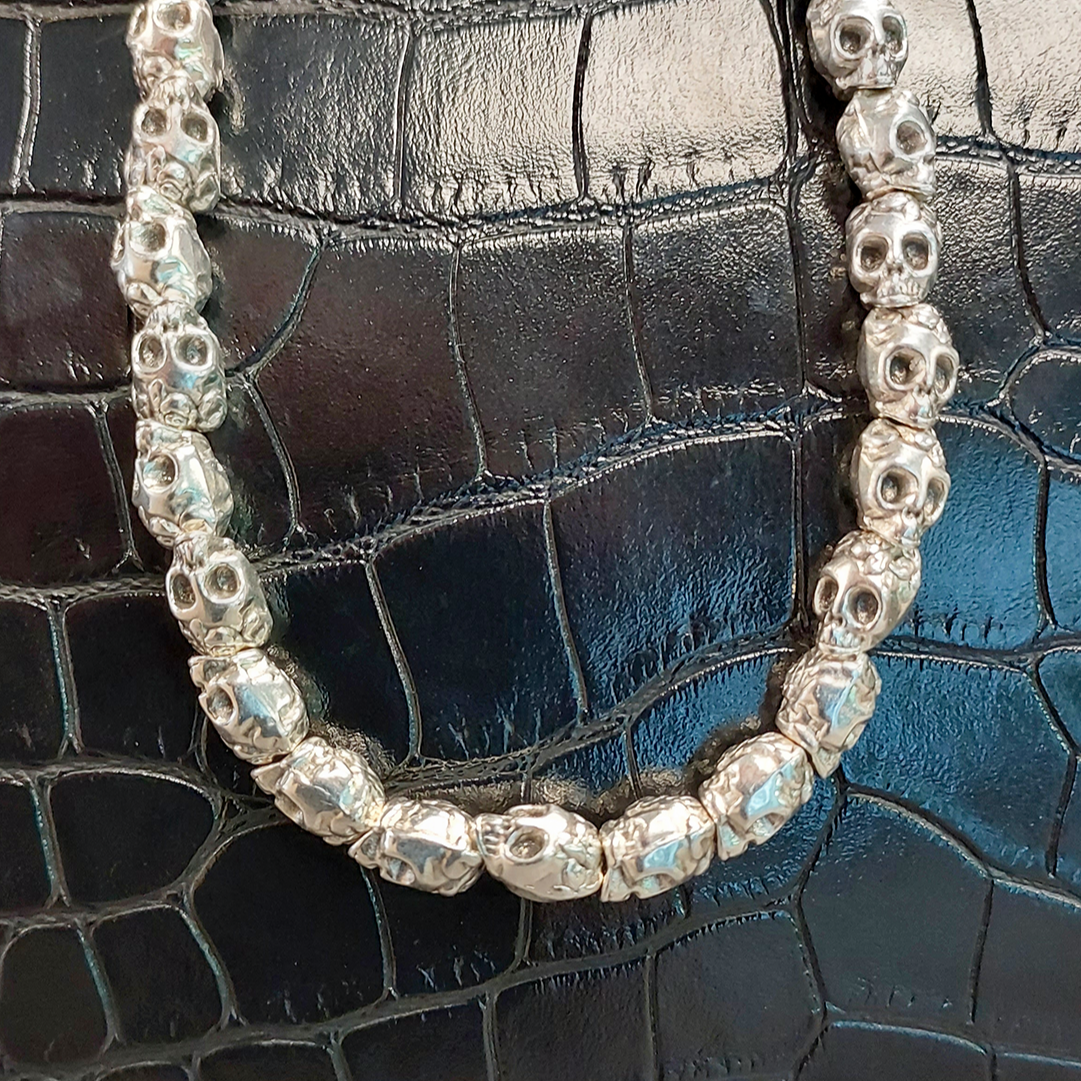 collar hombre calaveras sobre fondo grabado de oiel negra