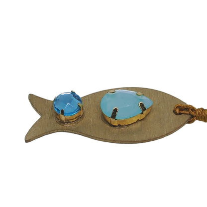 Pieza de collar en forma de pez de color dorado con piedras de bisutería en tonos azules