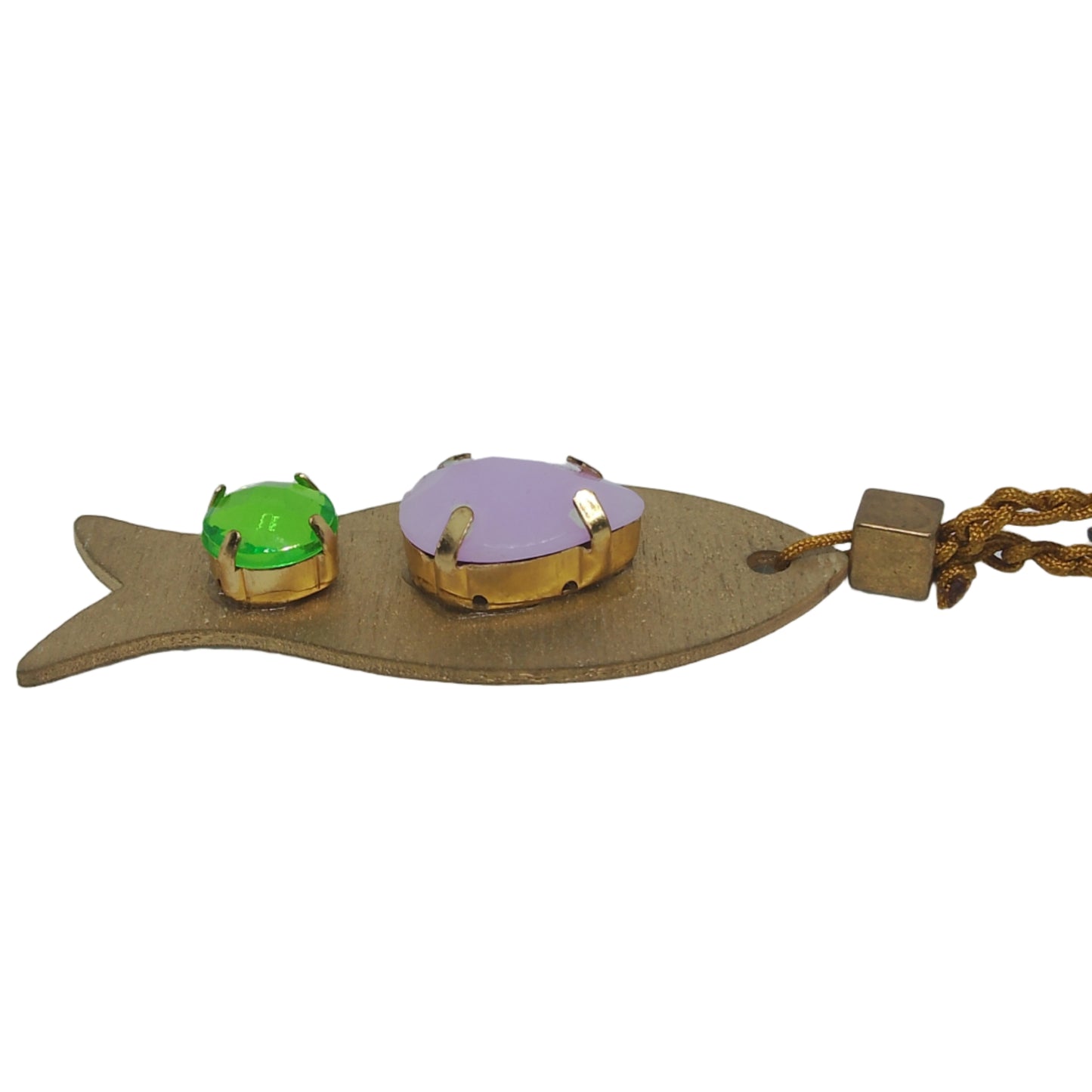 Pieza de collar en forma de pez de color dorado con piedras de bisutería con piedras lavanda y verde , visto de lado