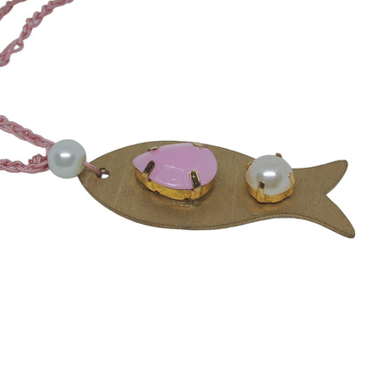 Pieza de collar en forma de pez de color dorado con piedras de bisutería con piedra rosa y perla visto de lado