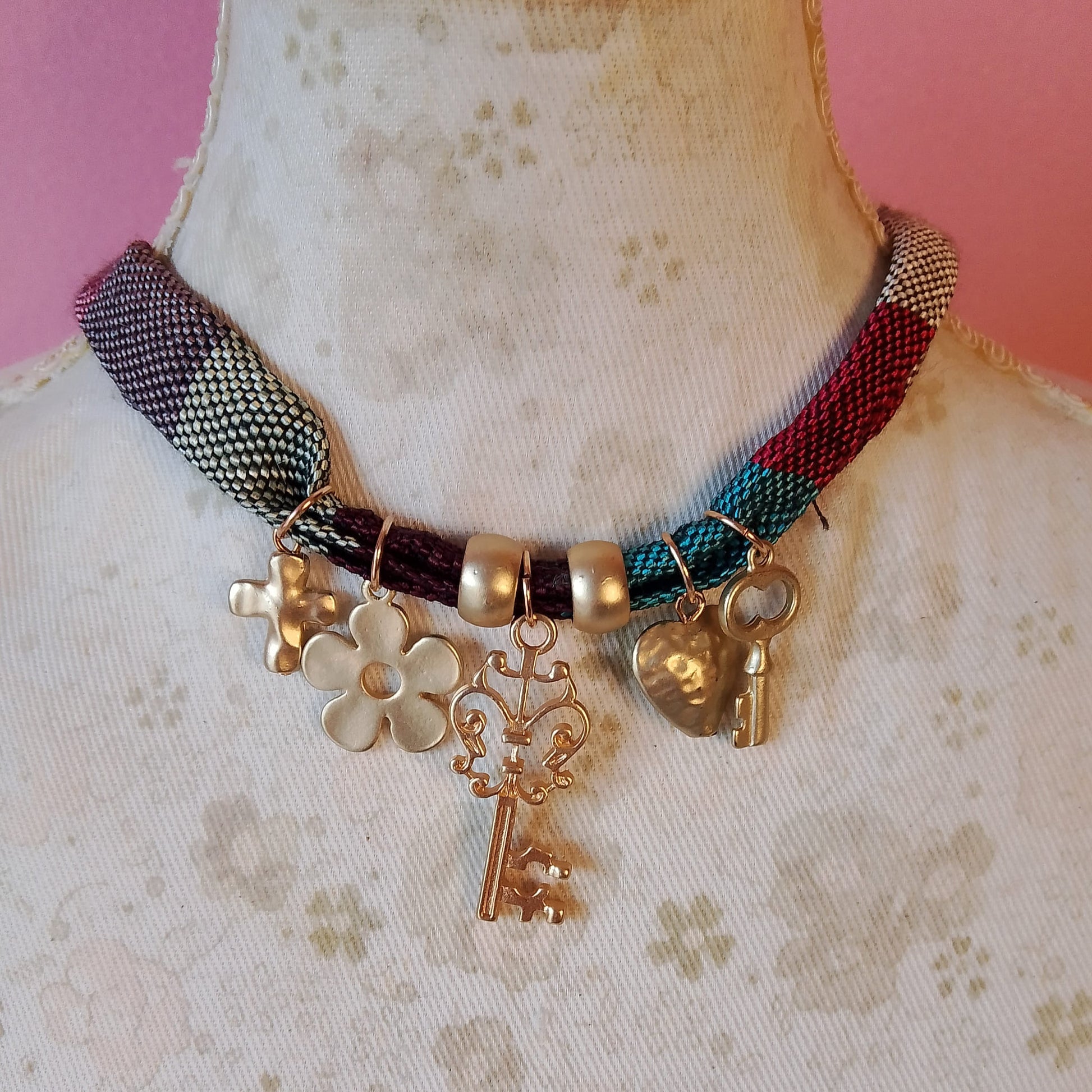 collar de tela con colgantes dorados cruz, flor, llave, corazon y llave pequeña