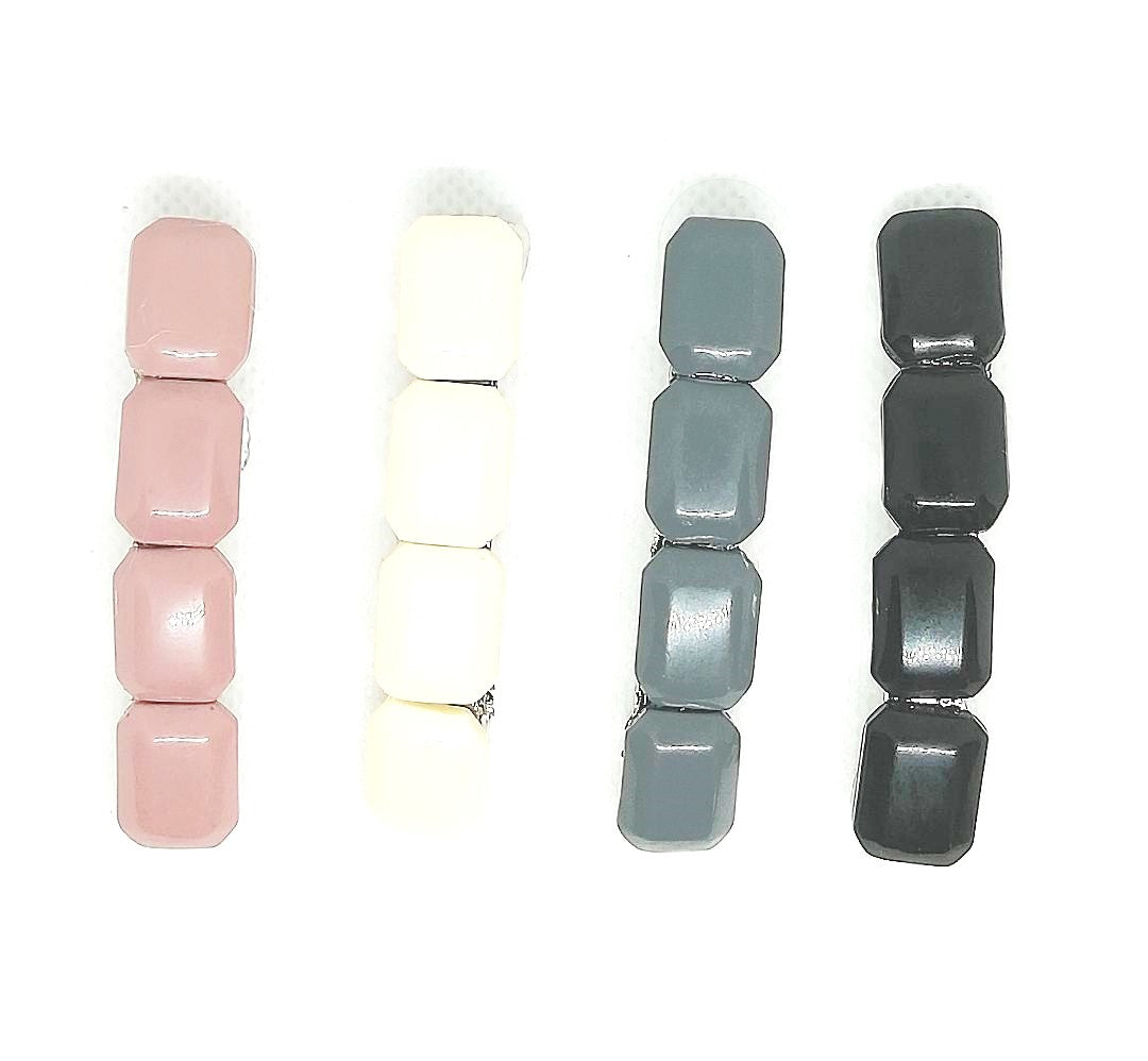 Pack de cuatro pasadores de pelo con piedras de plástico rectangulares . Color rosa, marfil gris y negro