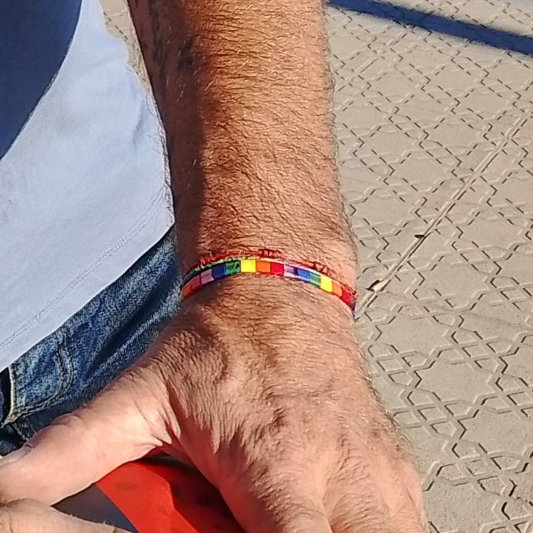 pulsera arcoiris puesta en mano de hombre