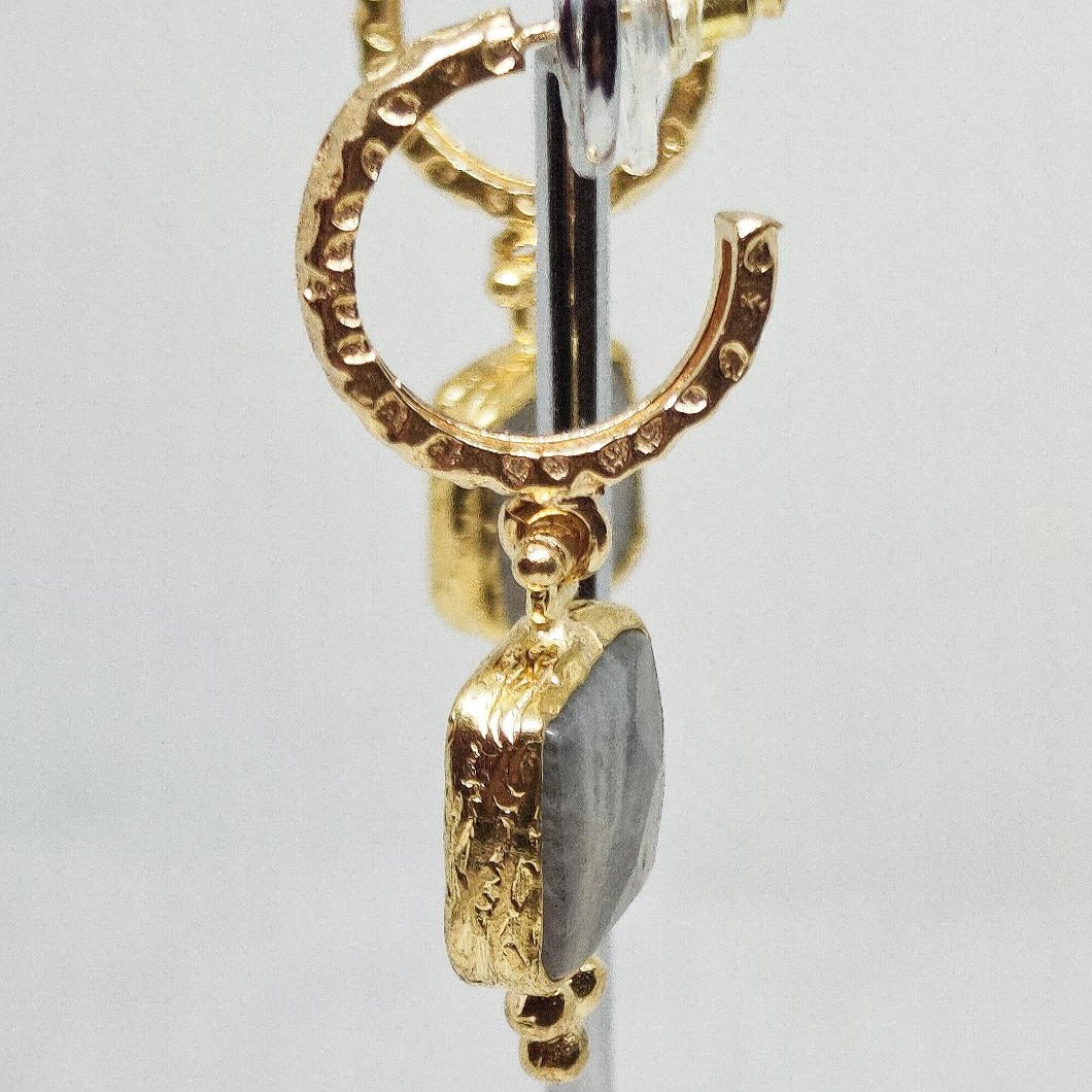 Pendientes de aro dorado con colgante cuadrado  de mineral gris. vista lateral